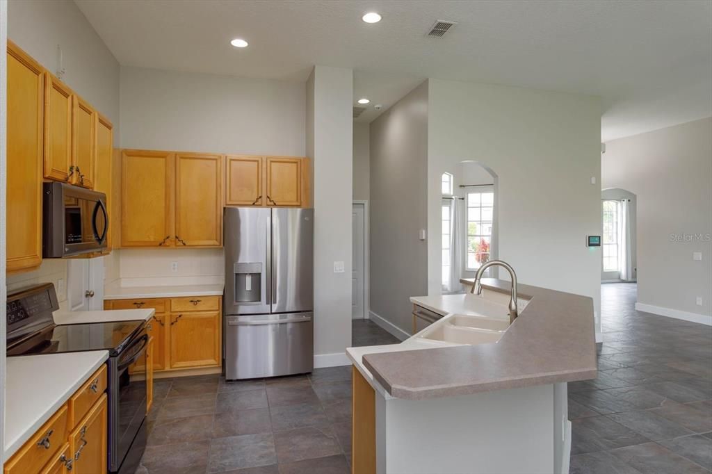 KITCHEN CONNECTS TO THE OVERSIZED GARAGE BY WAY OF THE INSIDE LAUNDRY ROOM COMPLETE WITH WASHER AND DRYER APPLIANCES TO CONVEY