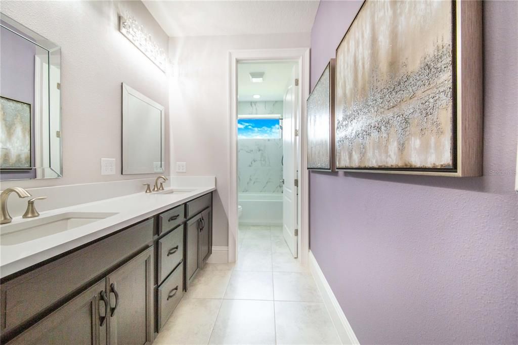 Upstairs Hall Bathroom has a Tub Shower Combination, Dual SInks and Heated Towel Rack