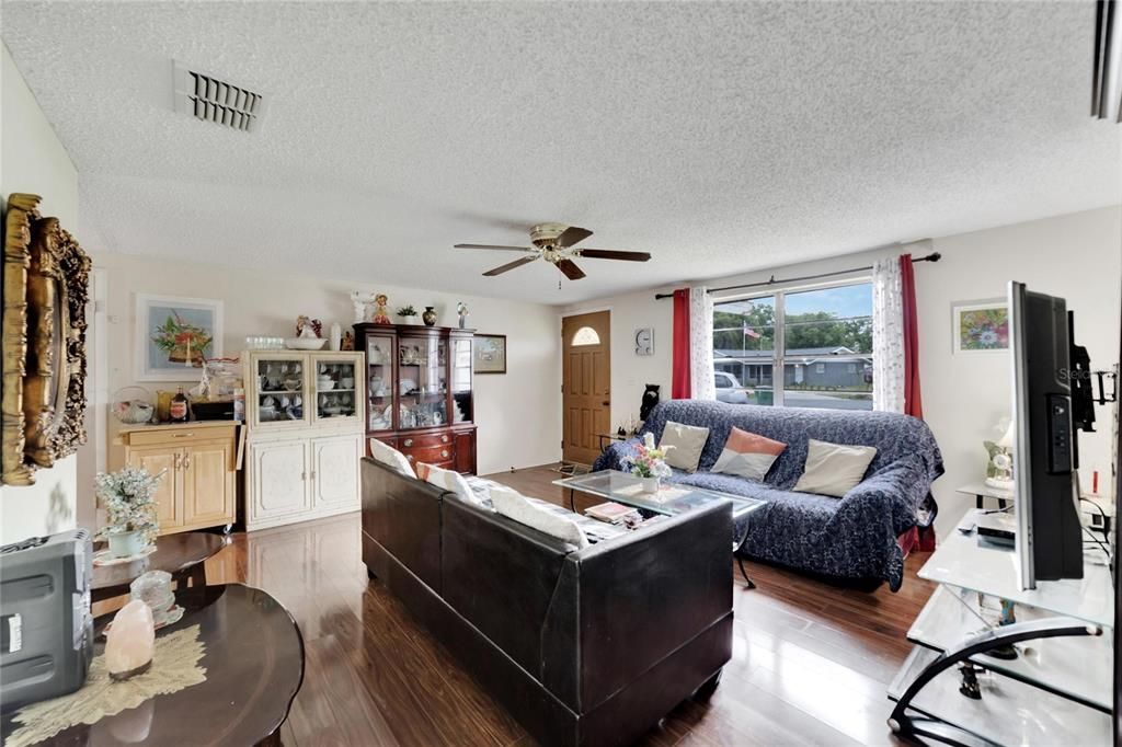 Living room view with ceiling fan and natural sunlight.