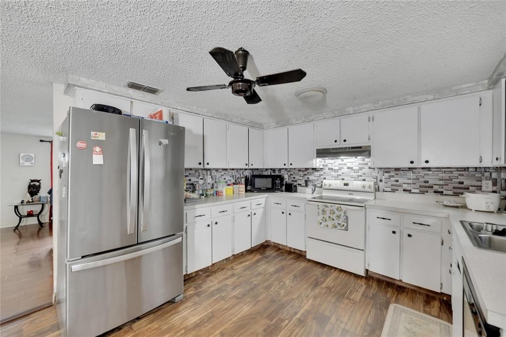 Kitchen view with double door fridge for extra storage.