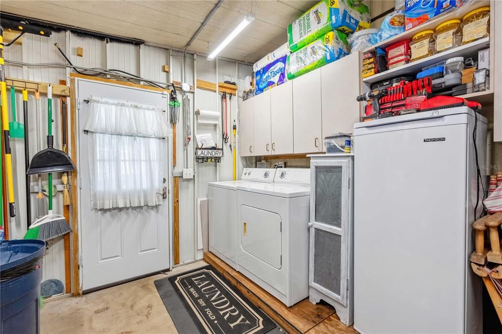 Laundry area is off the carport with roll up garage door.