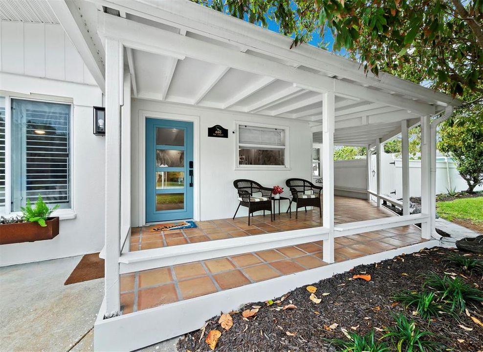 This spacious front porch has plenty of room for seating and wraps around to the primary suite.