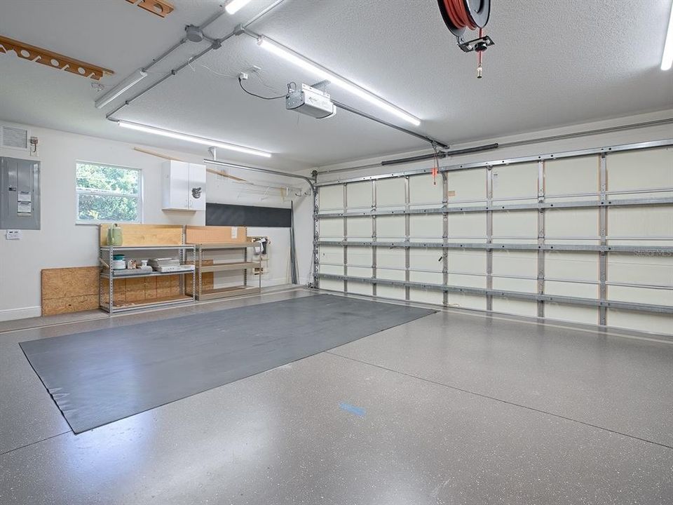SPACIOUS 2 CAR GARAGE WITH INSULATED DOORS AND A WORKBENCH.