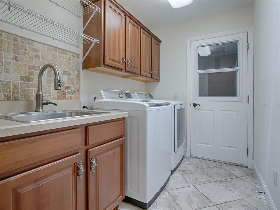 LAUNDRY ROOM WITH SINK, EXTRA CABINETS, SHELVING AND WASHER AND DRYER DO CONVEY WITH THE HOME.