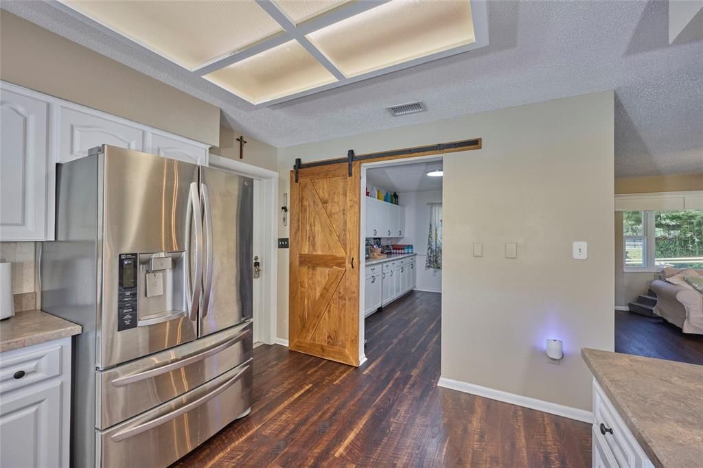 Kitchen with peek into pantry room.