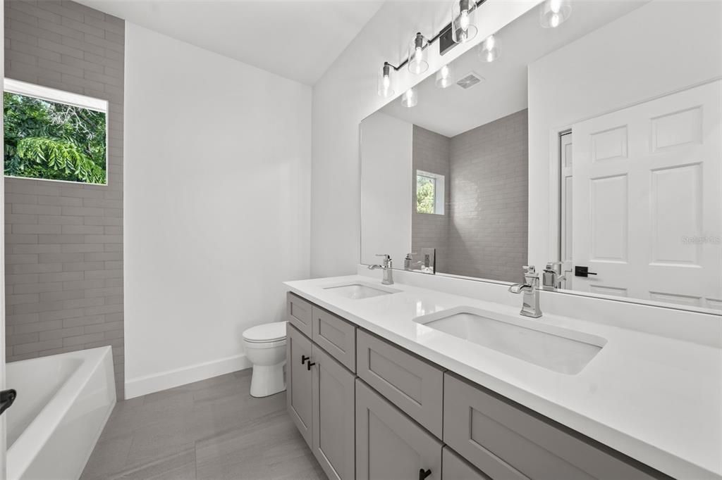 The secondary bath provides a double sink vanity