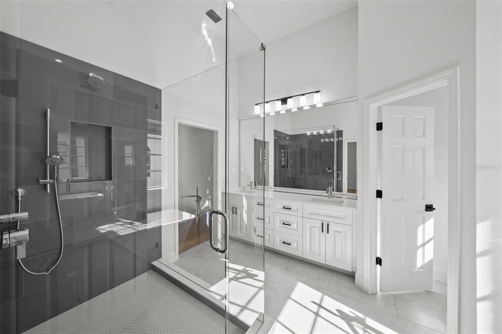 A spacious shower with floor to ceiling tile