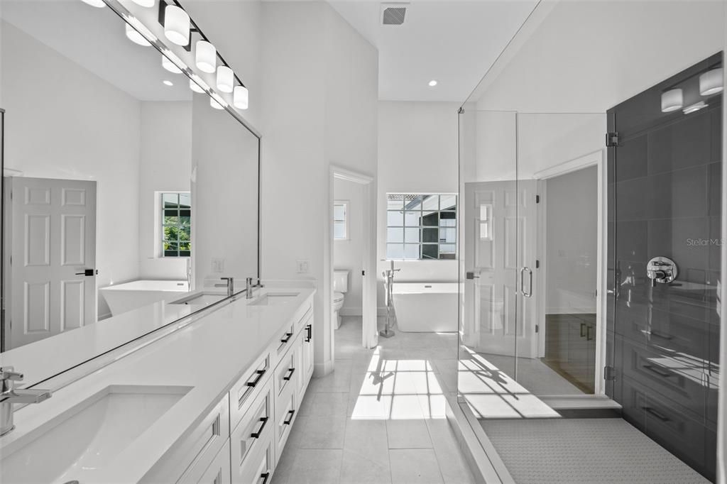 Primary bathroom offers a double sink vanity with quartz counters