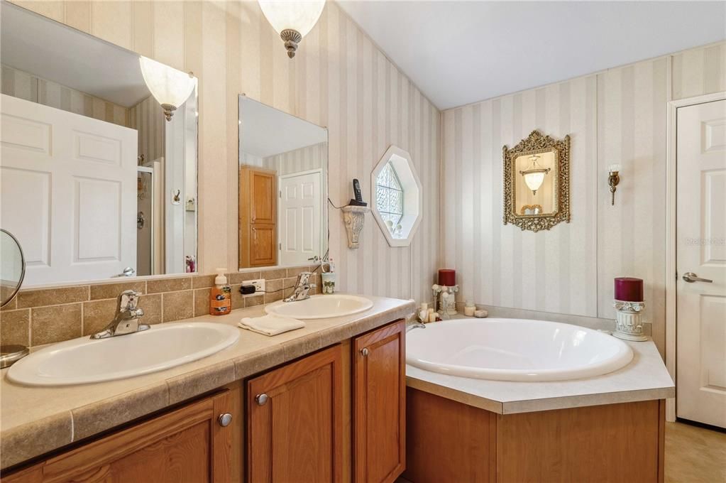 Primary retreat has step-in shower, double vanity, and tub.