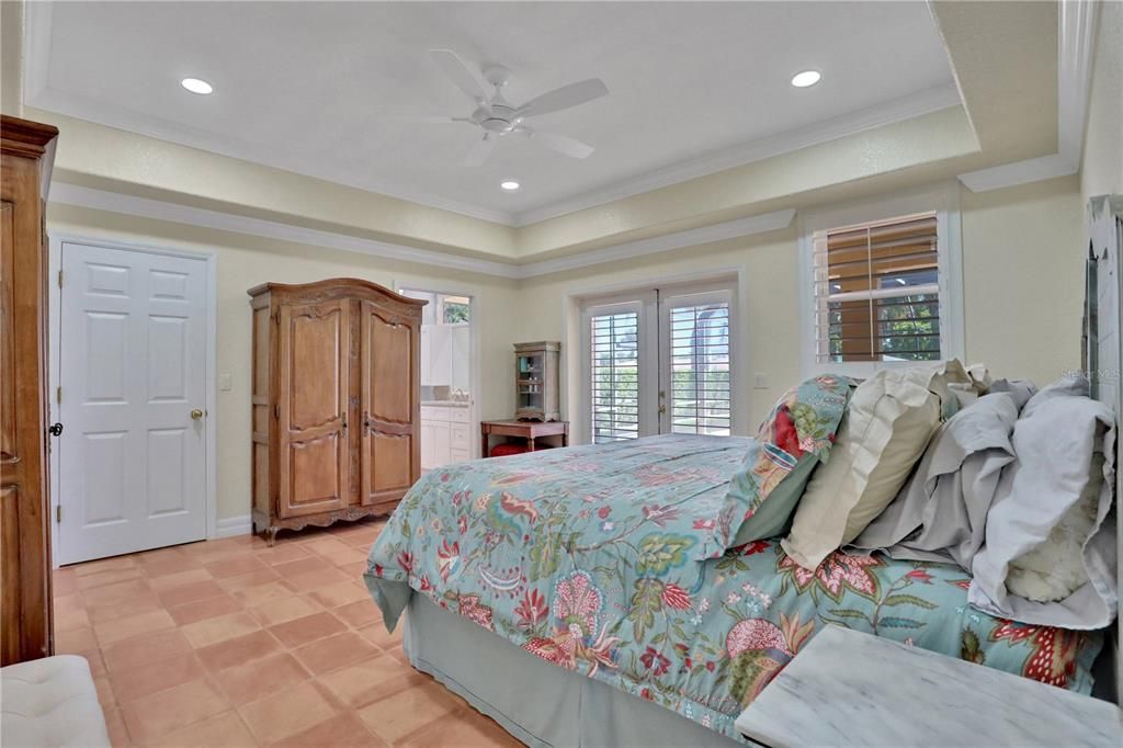 Primary bedroom with large walk-in closet and french doors to the lanai/pool.  primary home