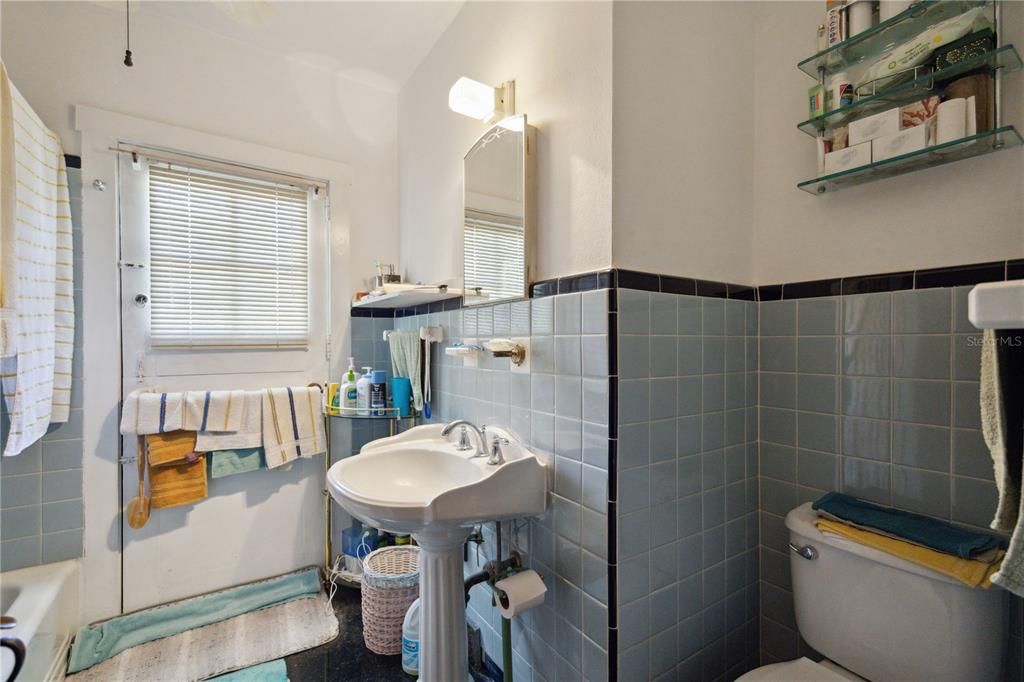 Nice ocean blue tile added around the full bathroom that comes with a full shower/ bathtub, along with a vintage ceramic sink. The exterior door with windows leads to the back deck, which is a bonus if you decide to add in a pool. Helps keep the wet foot prints where they belong!