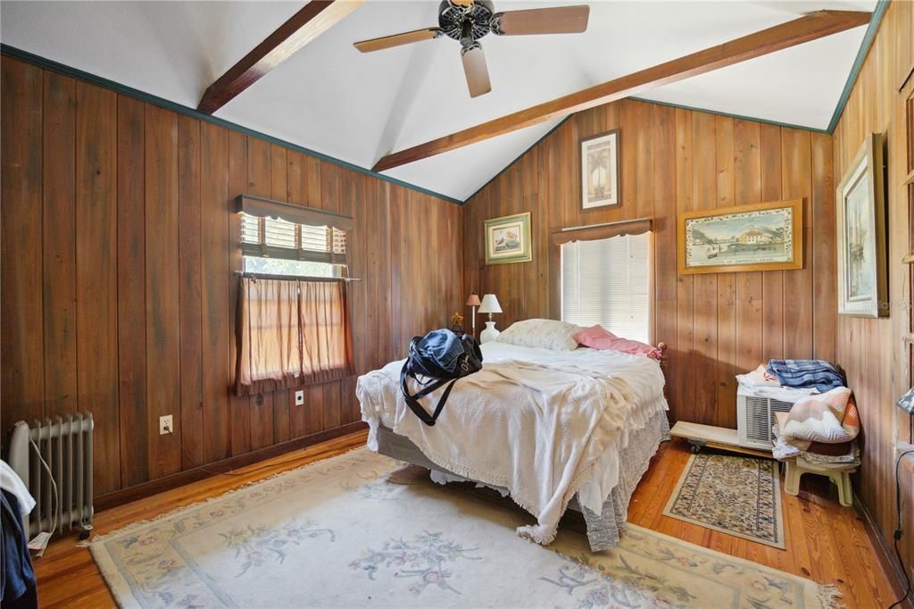 This is considered the master bedroom due to its spacious size, cathedral ceilings, extended built in closet with one window facing North and one window facing East. Check out the various arrangements of the original wood grain!