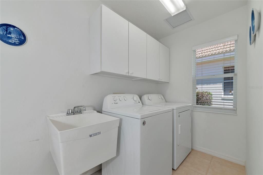 Inside laundry with cabinets & utility sink.