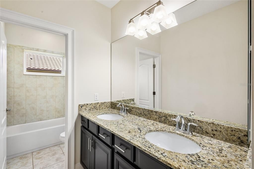 Full bath with dual sinks, granite counters and espresso vanity next to the media room and bedroom 3!