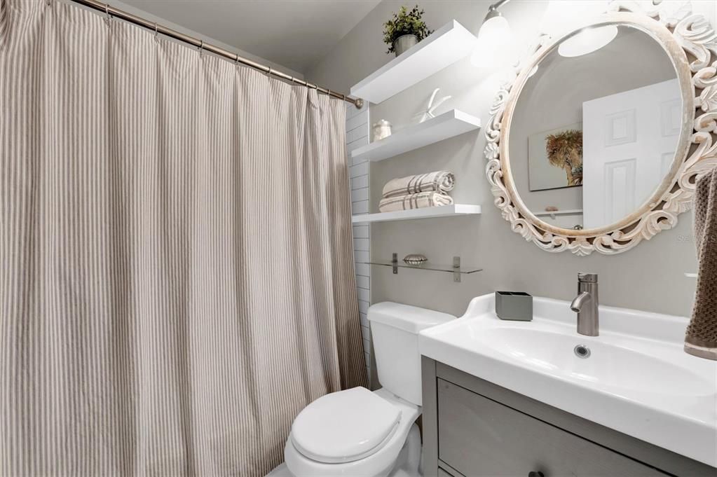 Cute updated bath. Both a tub and shower behind the curtain - and you can see a bit of the subway tile just past the toilet