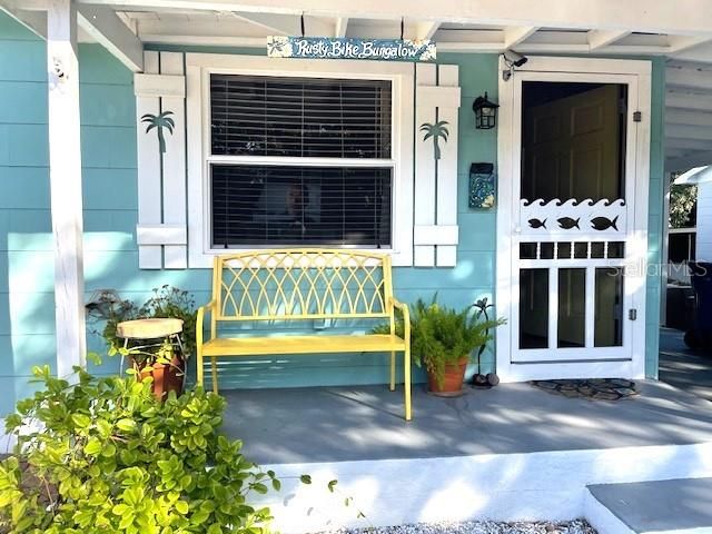 A closer look at your front porch - plenty of room for seating plus plants or decor. You can see the cute detailing on the front door/screen, windows  - and note the personalized mailbox!!