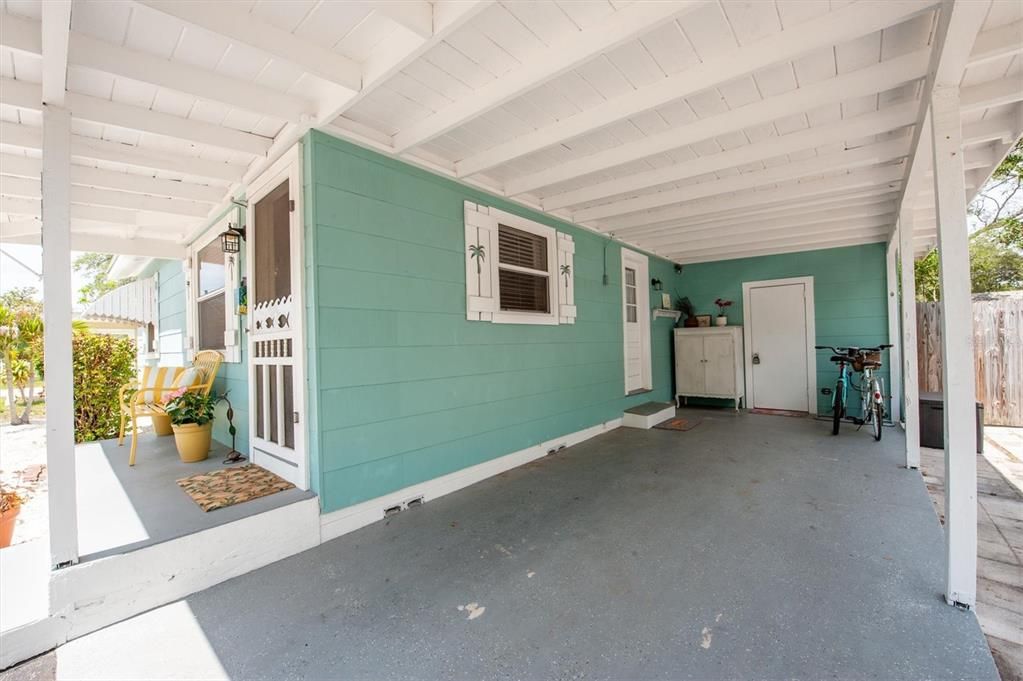 Plenty of space for seating and a plant or two on your welcoming front porch. The carport is very convenient. That door in back  is the laundry room.