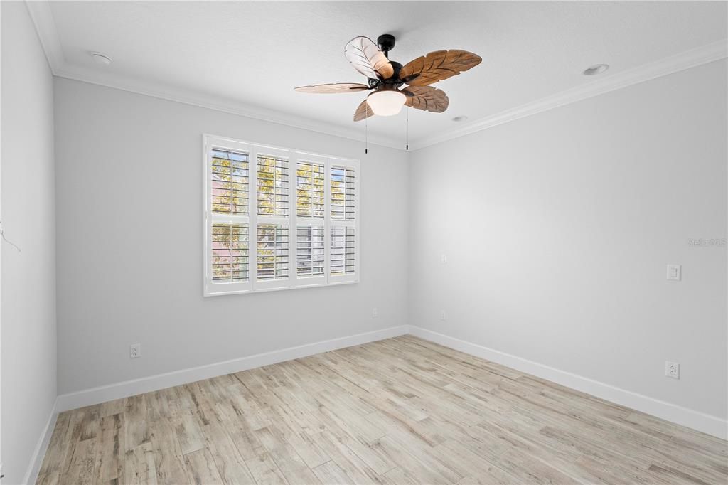 Entering the primary suite. Plantation shutters and tropical ceiling fan.