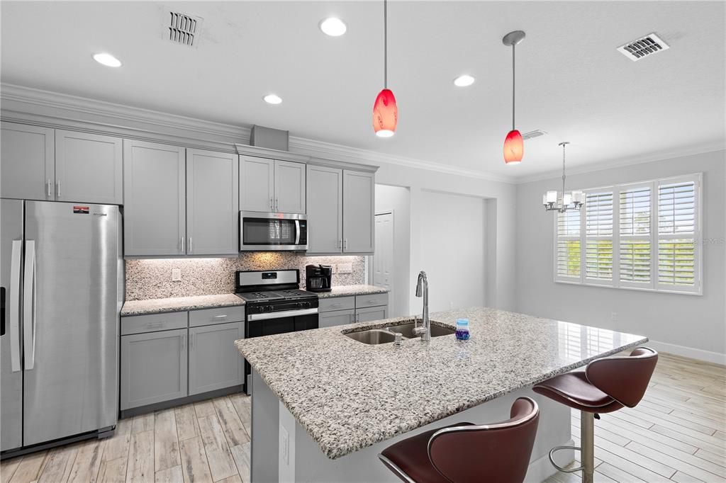 Prepare your favorite meals in the spacious eat-in kitchen that shows off stainless steel appliances, tall cabinetry, a large island and a beautifully matching granite backsplash.