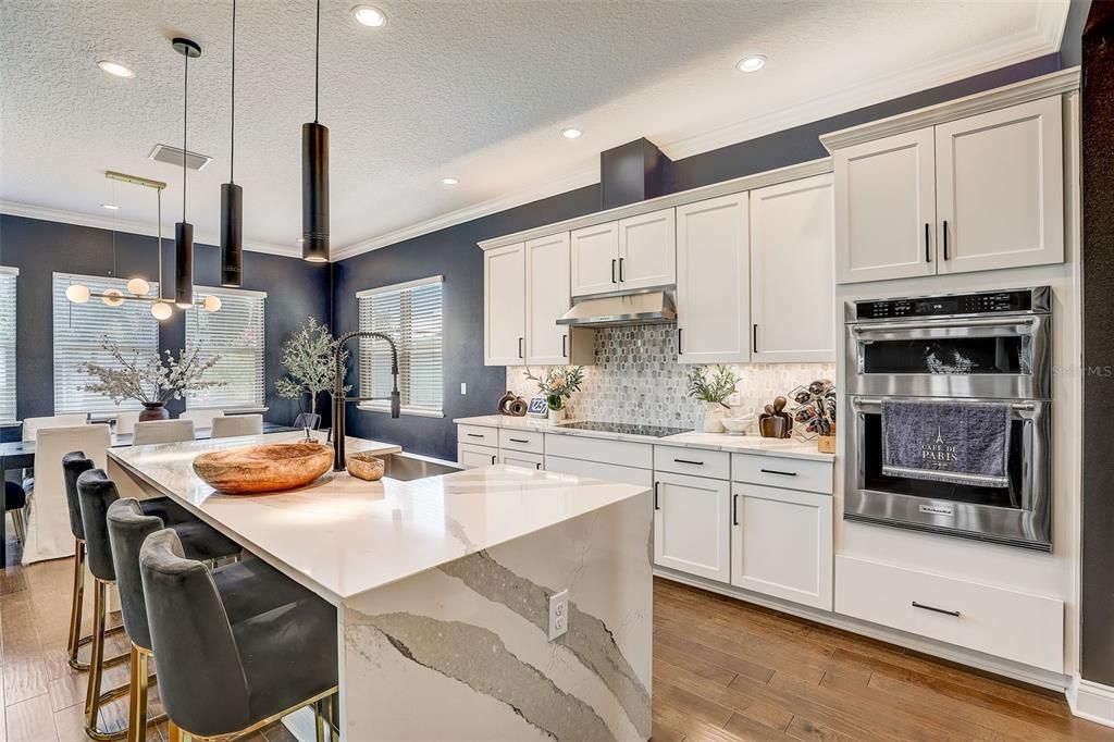 LEVEL 7 QUARTZ COUNTERTOPS in the kitchen, KITCHEN ISLAND WATERFALL DESIGN, NATURAL GAS BOSCH INDUCTION COOKTOP, EXTENDED KITCHEN ISLAND, GOURMET KITCHEN FEATURES