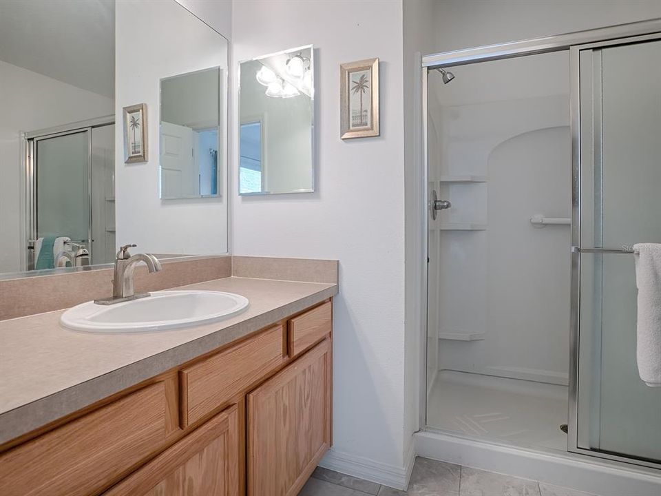 THE MASTER BATH HAS A SPACIOUS WALK-IN SHOWER WITH BUILT-IN SHELVING