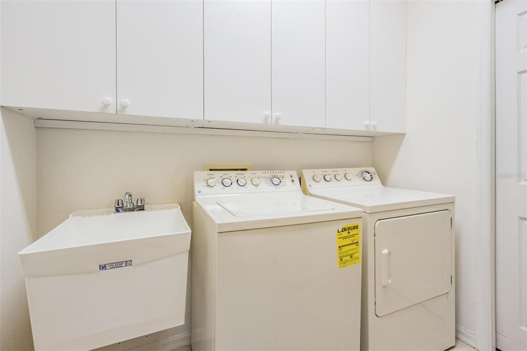 Walk-in laundry room with storage and utility sink
