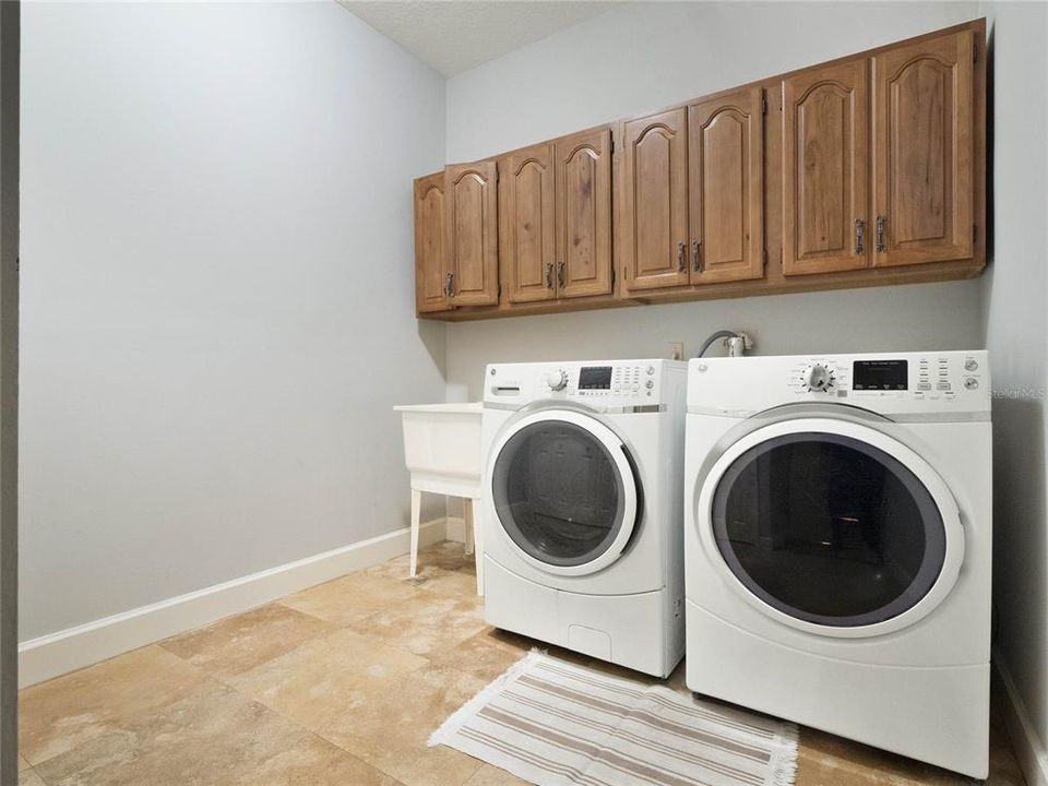 Laundry room with utility sink and cabinets.