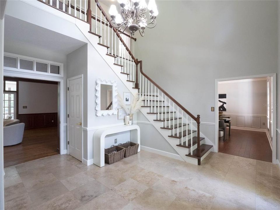 Upon entering, you are greeted by the grandeur of soaring ceilings and a graceful winding staircase.
