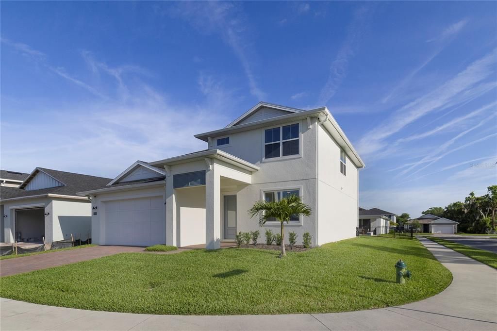 The paver driveway and two car garage complete with built-in cabinetry and a mini split A/C welcome you home and offer plenty of parking and storage options while the coastal details add a touch of charm!