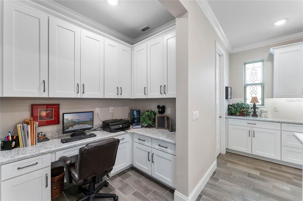 7'x6' pocket office with custom cabinetry, built in desk and crown molding
