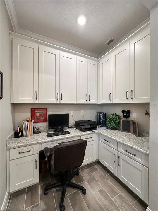 7'x6' pocket office with custom cabinetry, built in desk and crown molding