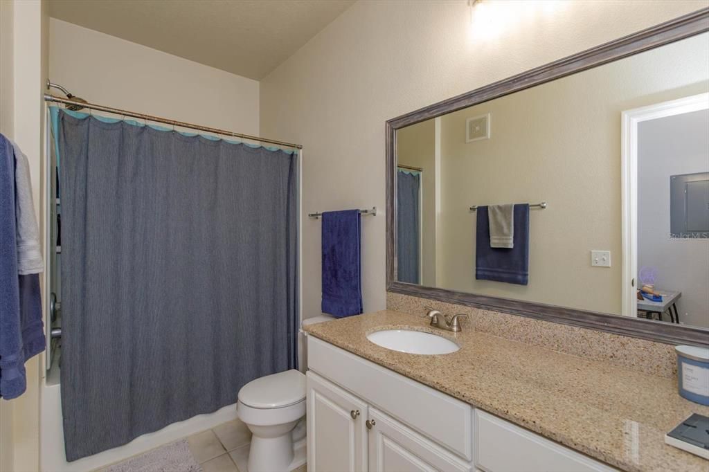 Hall bath with granite counters and a tub/shower combo