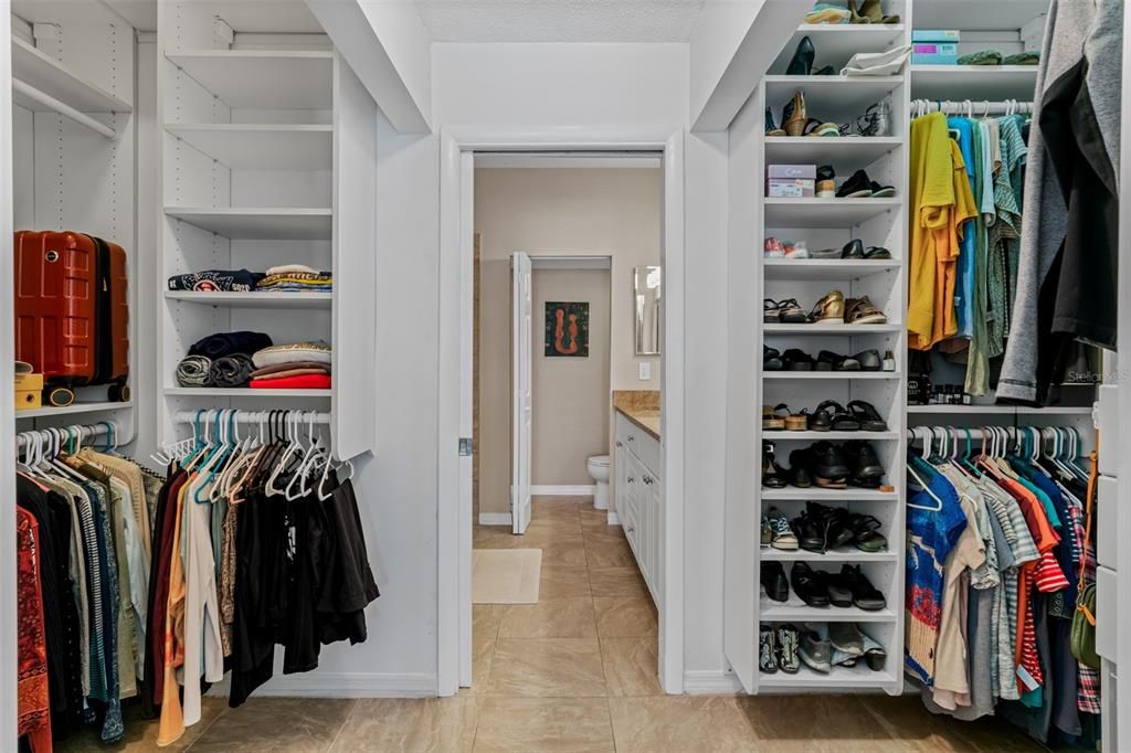 Primary walk in closet with built in shelving