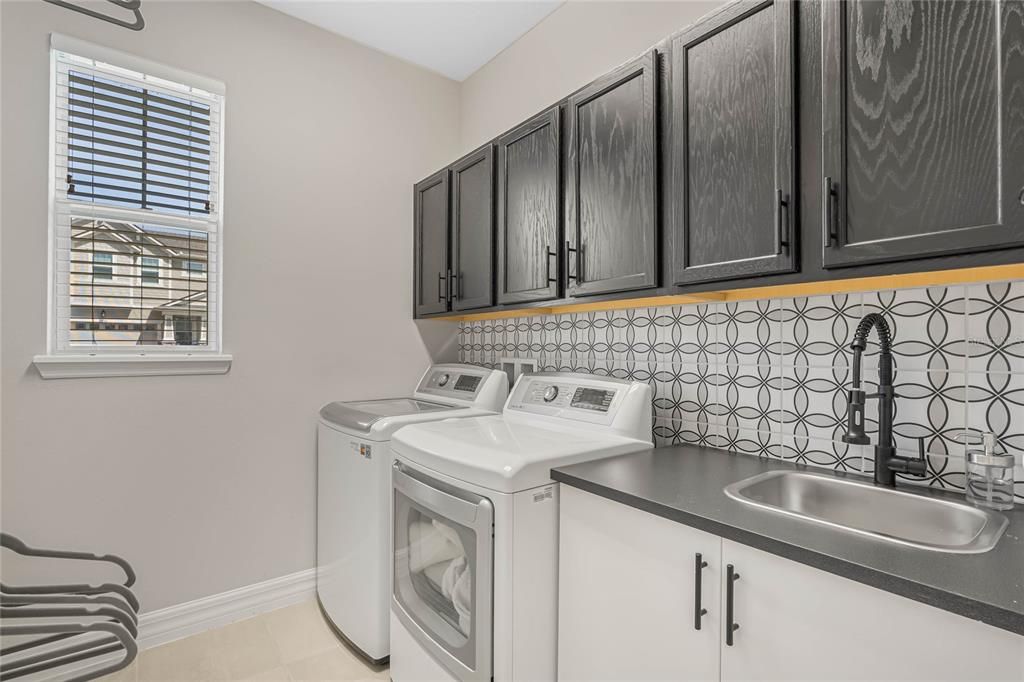 Upgraded laundry room with extra cabinets and work sink
