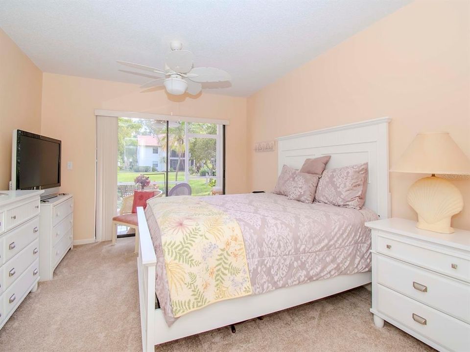 The primary bedroom features new carpet, new ceiling fan, and sliding glass doors to its private lanai.