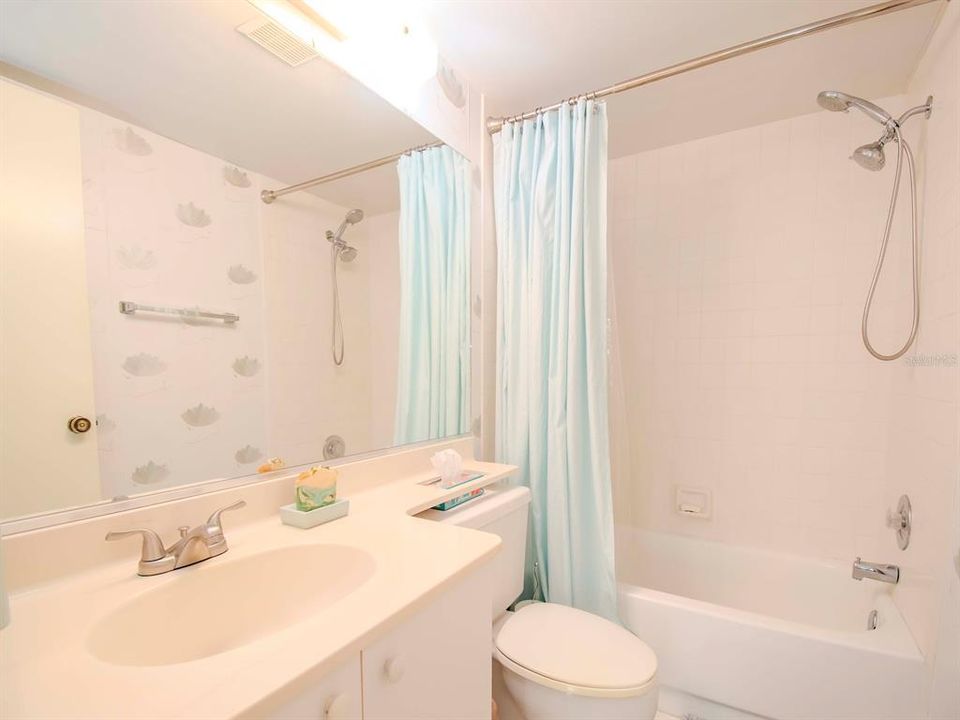 The guest bathroom offers a tub-shower combination.