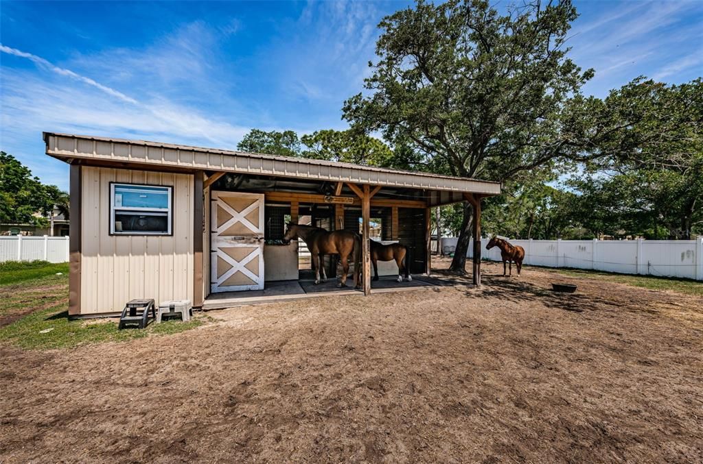 Barn with 2 12x 12 stalls with fans, water spraying system, electric, security lights, tack room, feed room, and hay loft.