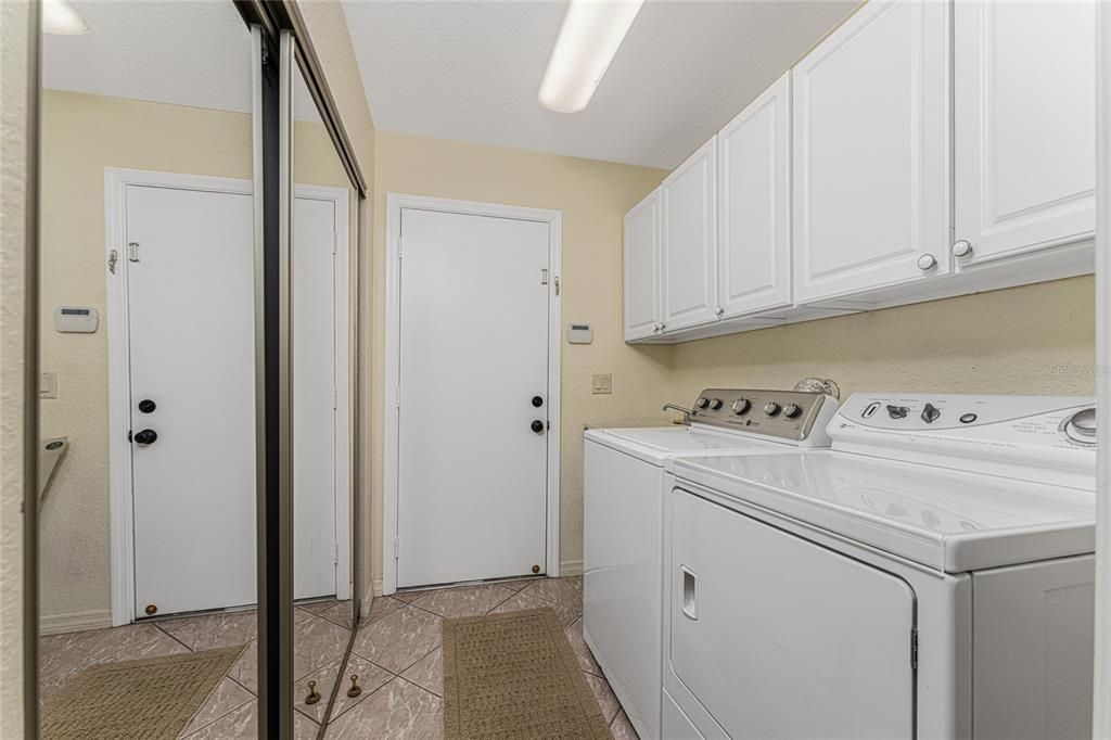 Laundry room off kitchen with large closet & cabinets