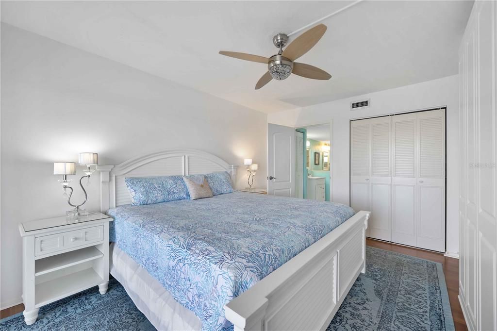Primary bedroom with en suite bathroom overlooking the lanai and bay.  Walk-in closet and added storage closet. Furnished.