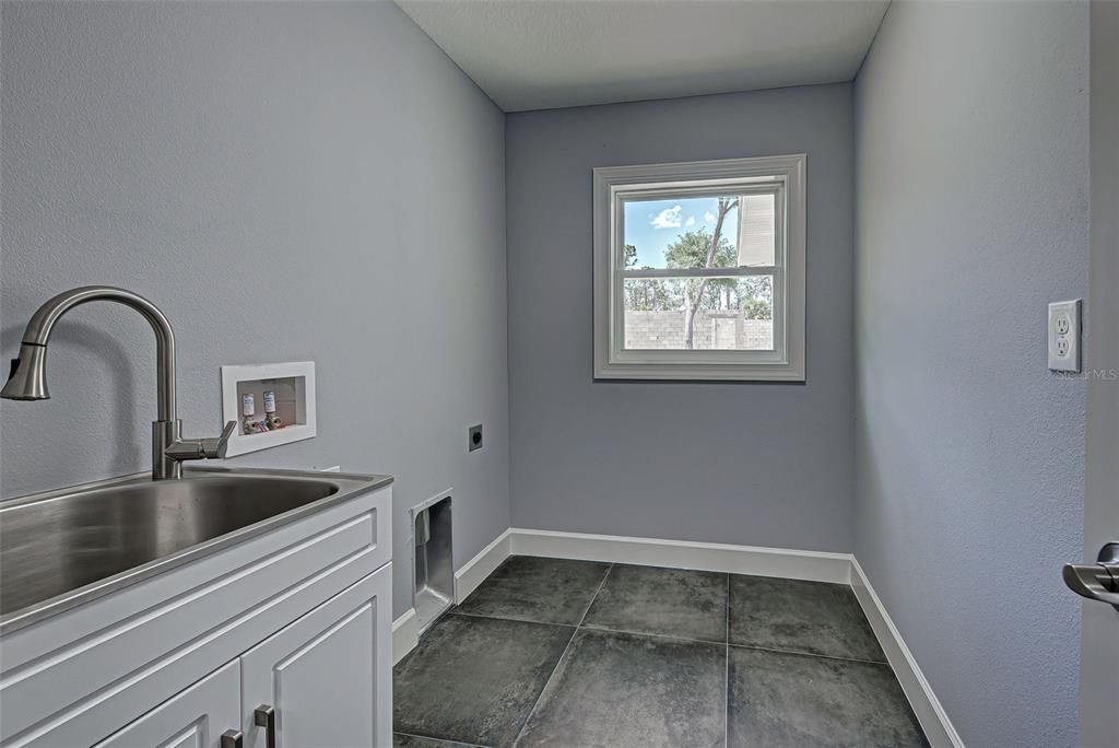 Large, interior laundry room has sink and door for privacy.