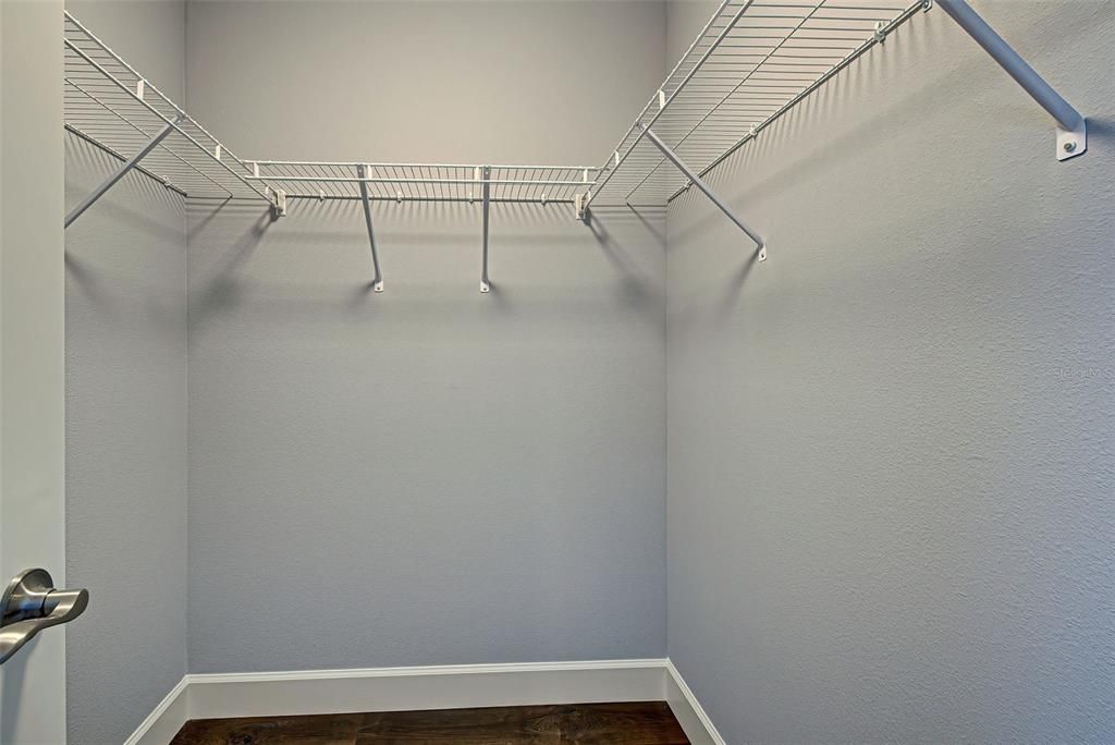 Primary suite features 2 large, walk-in closets with built in shelving - lots of storage space.
