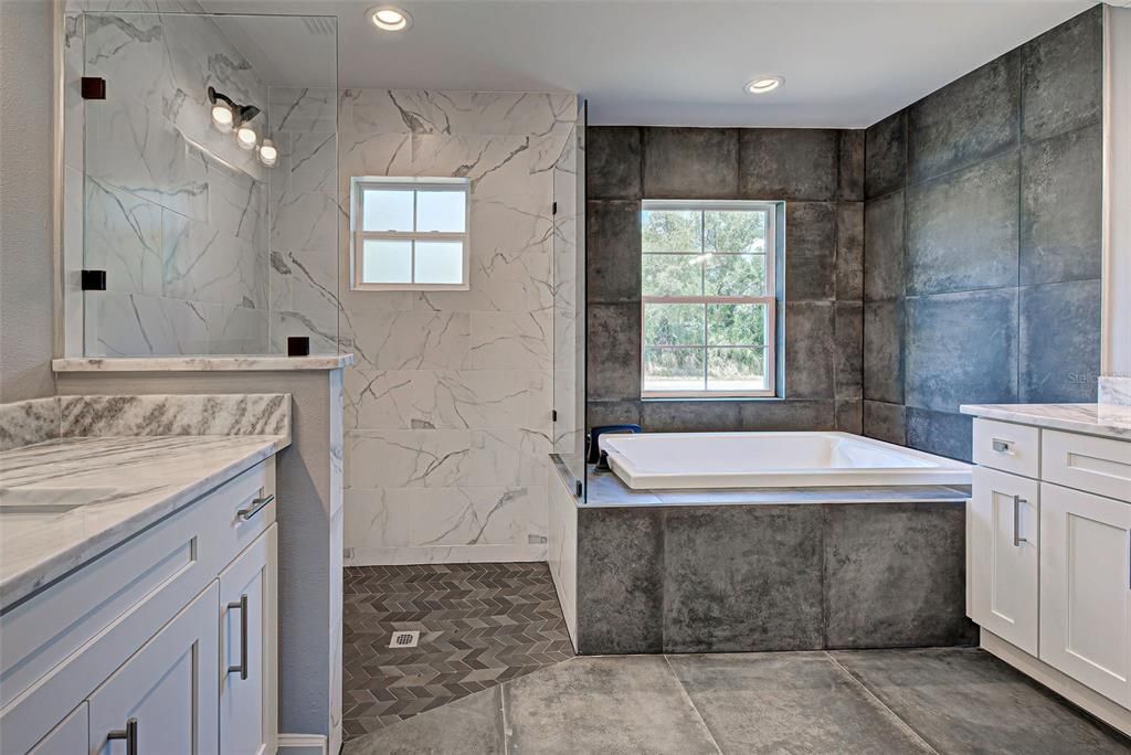 You will feel so pampered in the sumptuous ensuite bathroom with its gleaming quartz countertops and enormous Roman shower with gorgeous tile work.