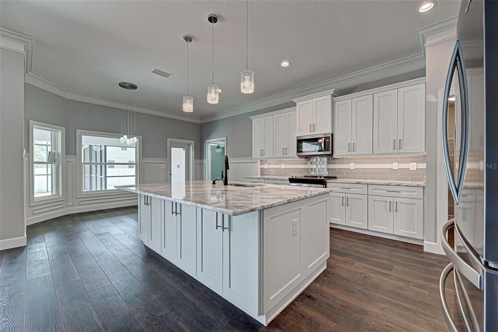 Gourmet kitchen will delight the chef in the family with its classy quartz island with large breakfast bar and 42" solid wood cabinets with soft close drawers.