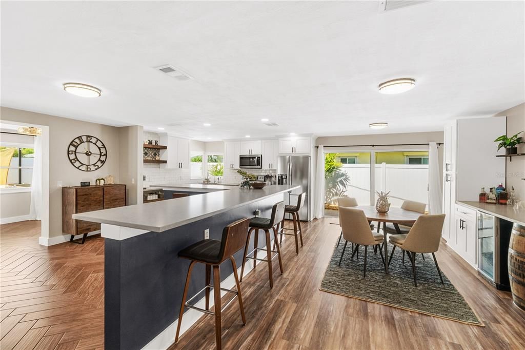 Enter this lovely Open Kitchen with plenty of seating for guests, Beautiful Flooring, Quartz Countertops and Upgraded Stainless Steel Appliances