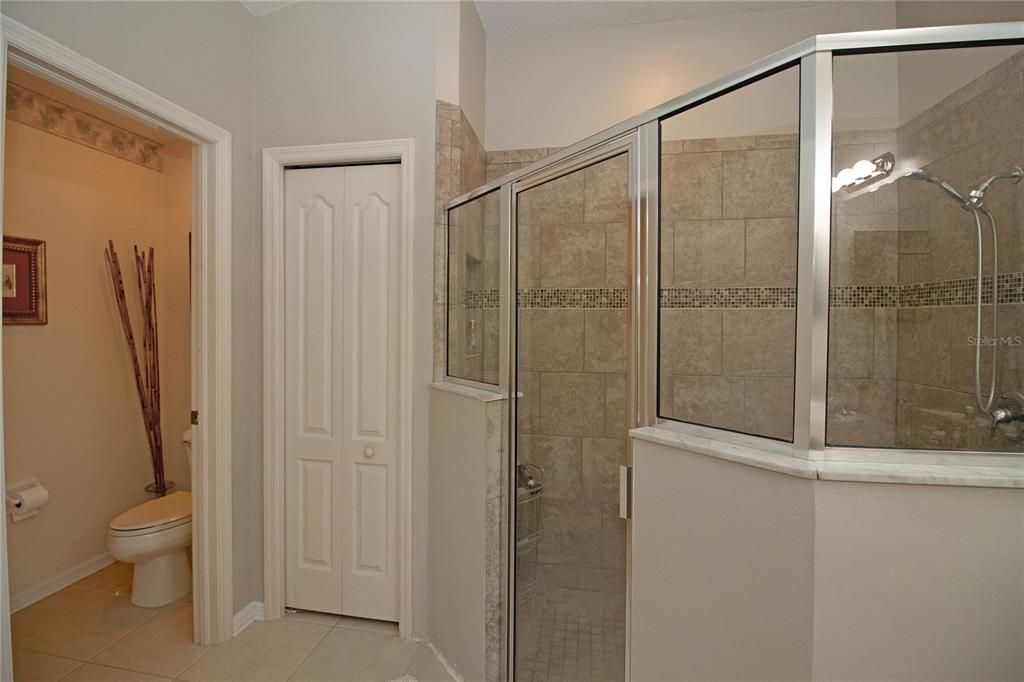 Primary Bathroom with dual sink vanity, walk-in shower, walk-in closet and private toilet