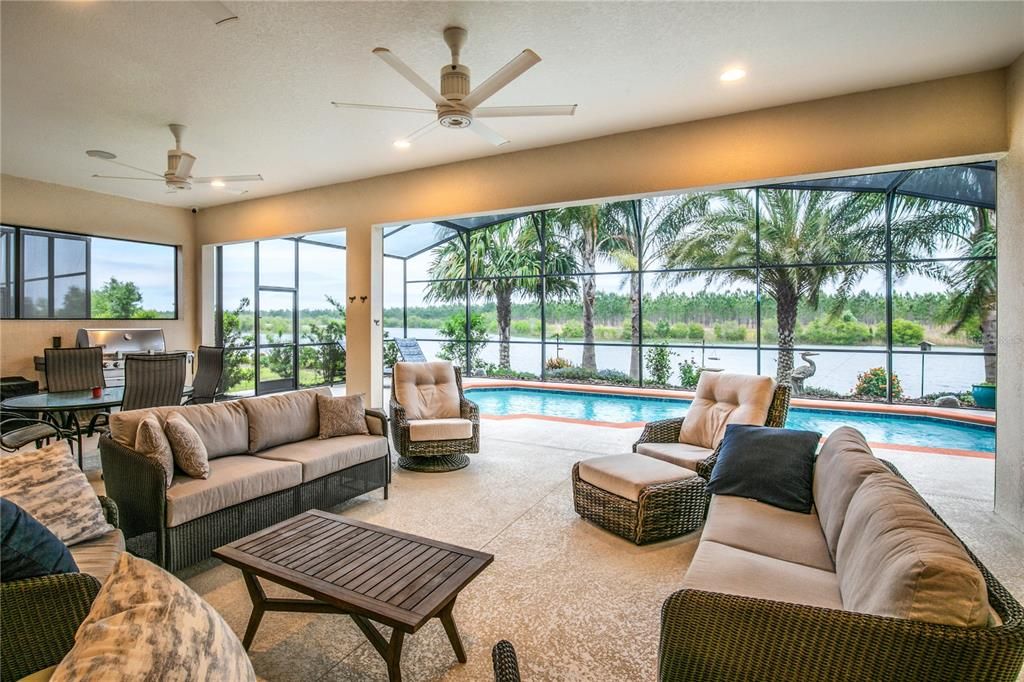 Large outdoor screened lanai with pool and water view