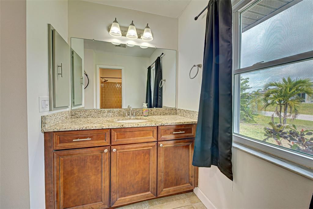 Primary bath has plenty of storage, newer light fixtures and natural light.