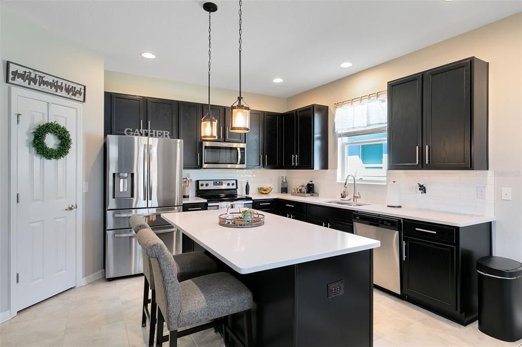 Adorned with gorgeous quartz counters, stainless steel appliances, and a modern tile backsplash.