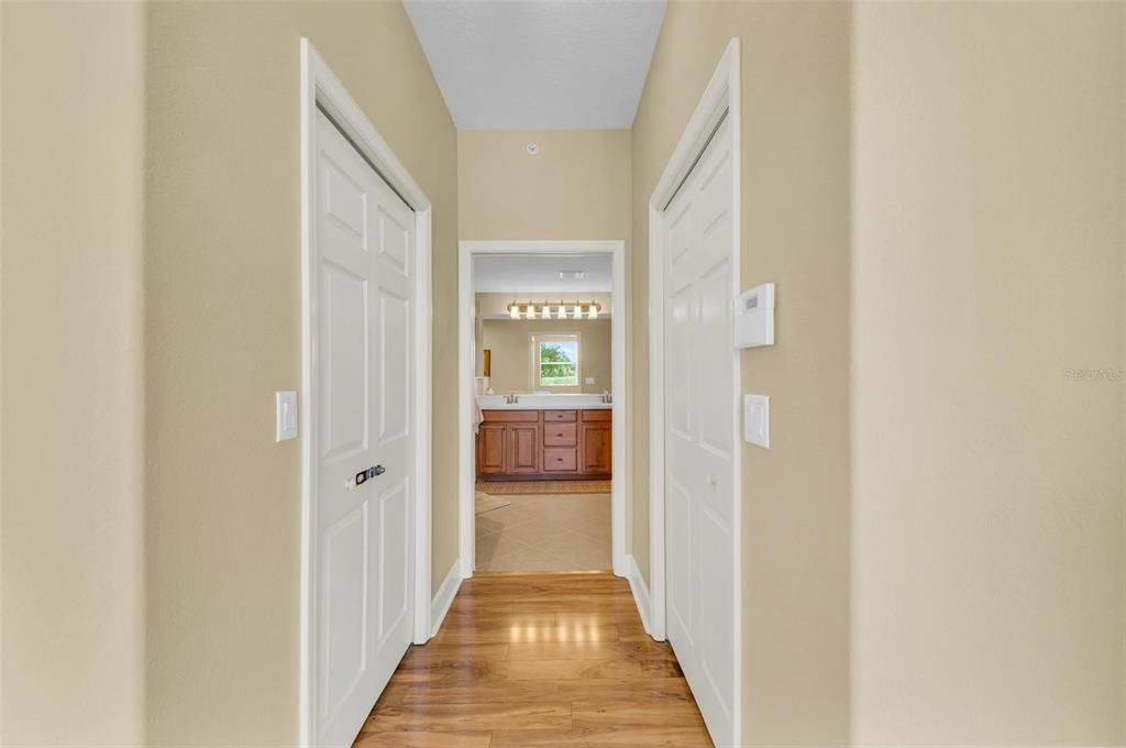 Hallway to Owner's Bathroom with Walk-in Closets on either side.