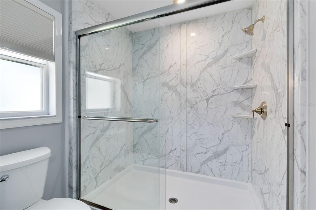 The updated ensuite master bath boasts a modern dual sink vanity and a luxurious walk-in shower.